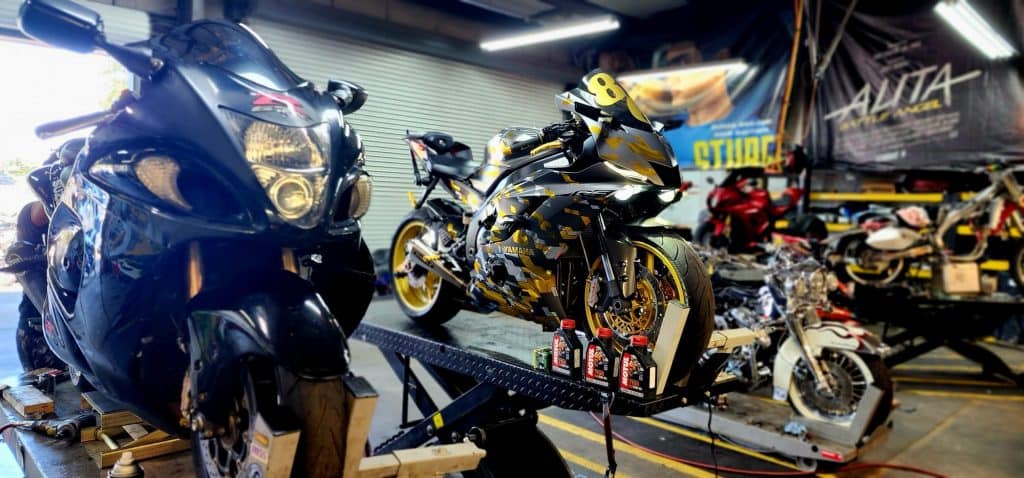 black and yellow motorcycle receiving maintenance.