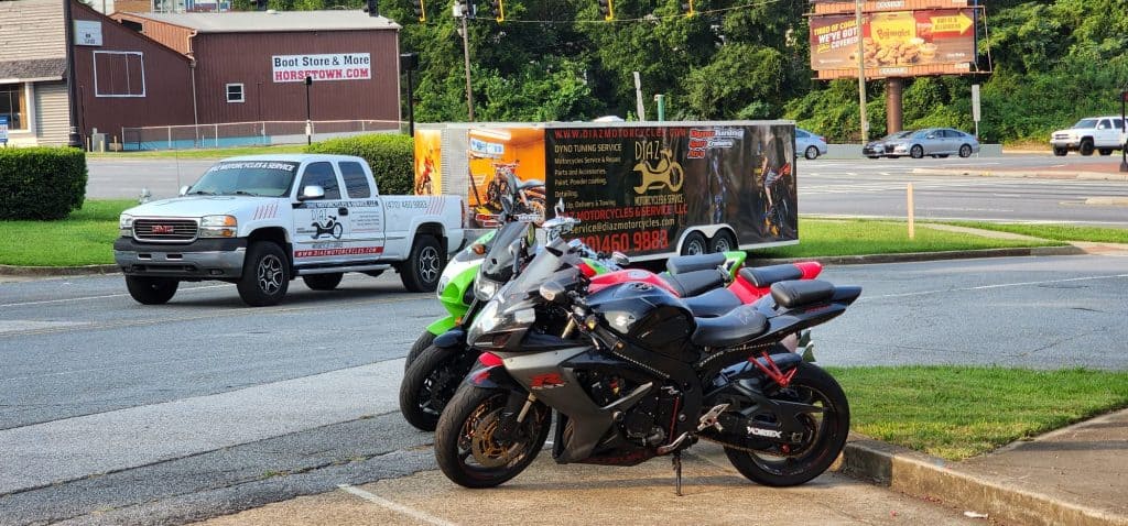 motorcycles parked with diaz motorcycle transportation trailer in background.