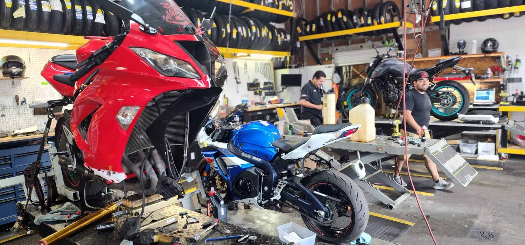 motorcycle maintenance being performed on a blue motorcycle.