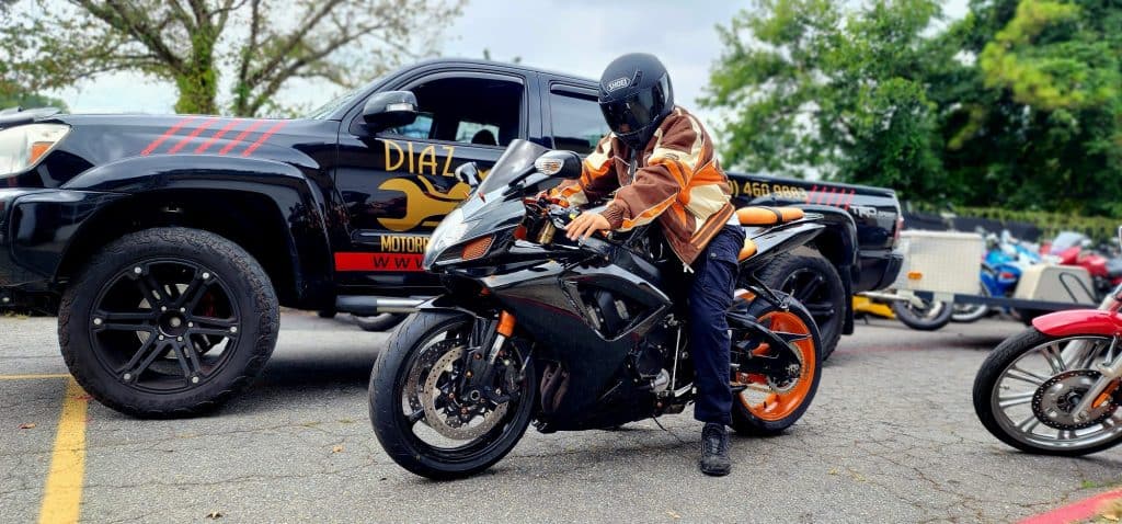 orange and black motorcycle with a rider in matching jacket.