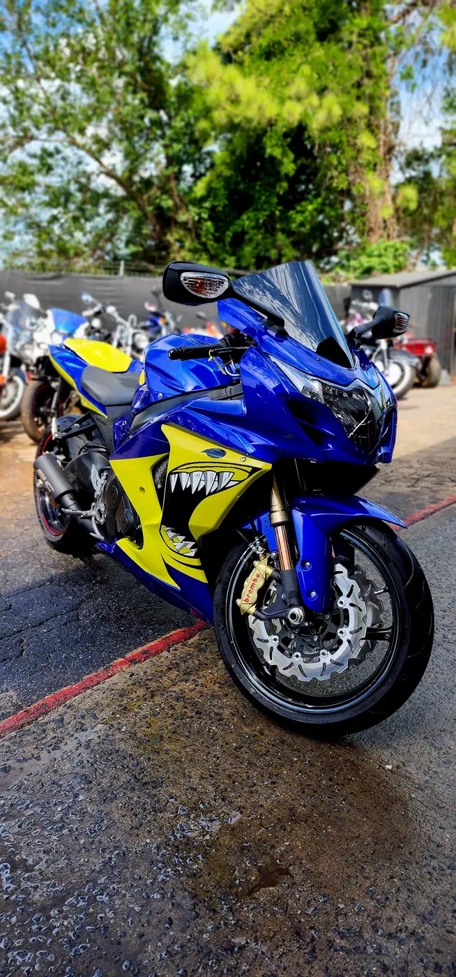 Faded motorcycle paint Dallas fix example — blue and yellow Suzuki GSX-R with a shark-teeth fairing graphic
