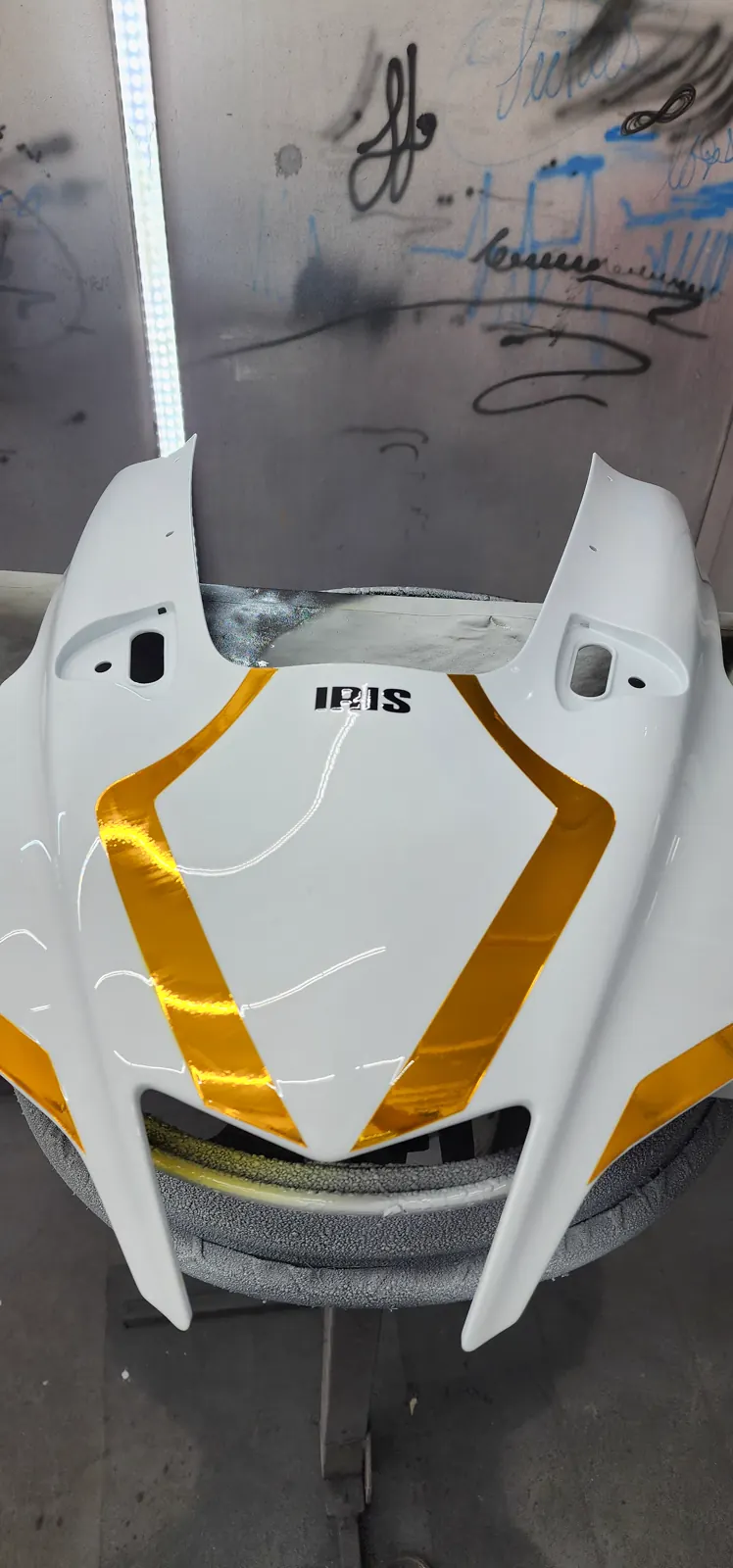 custom paint cost Kennesaw — white and gold fairing on a foam stand inside the Diaz spray booth