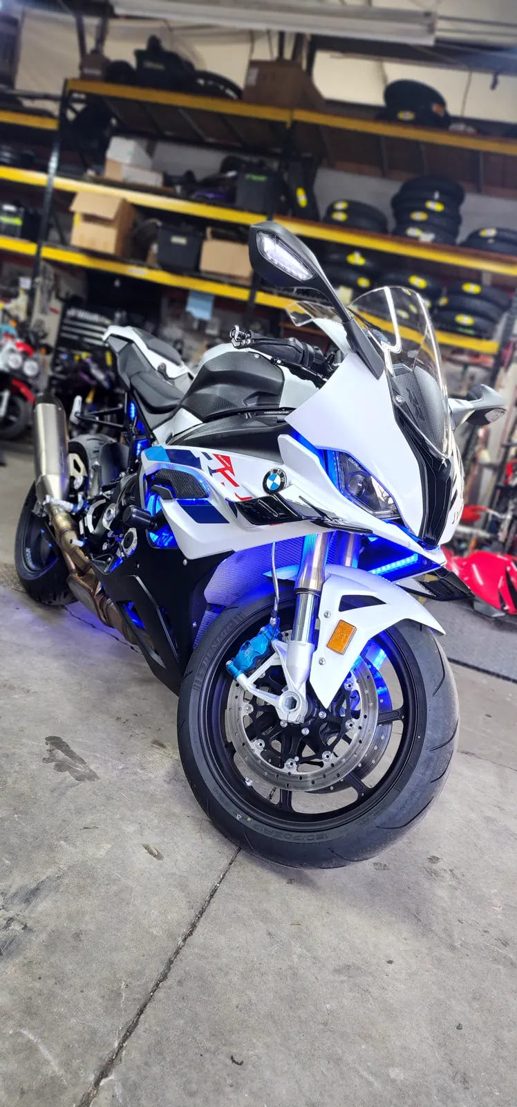 custom paint Atlanta — white, blue and red BMW S1000RR with blue underglow lit up on the shop floor