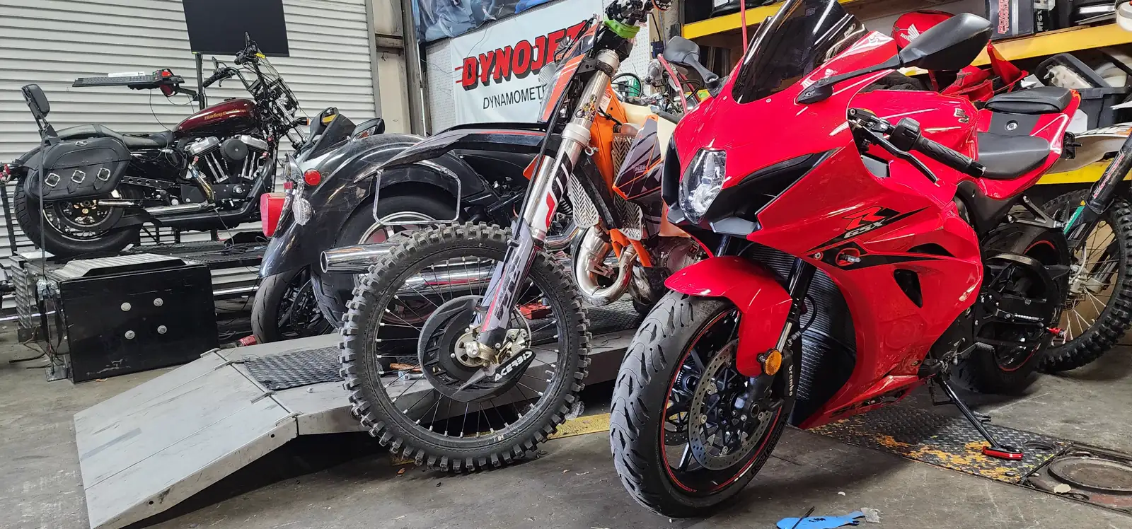 dyno tuning Peachtree City — a Harley Sportster, KTM dirt bike and Suzuki GSX-R staged around the dyno