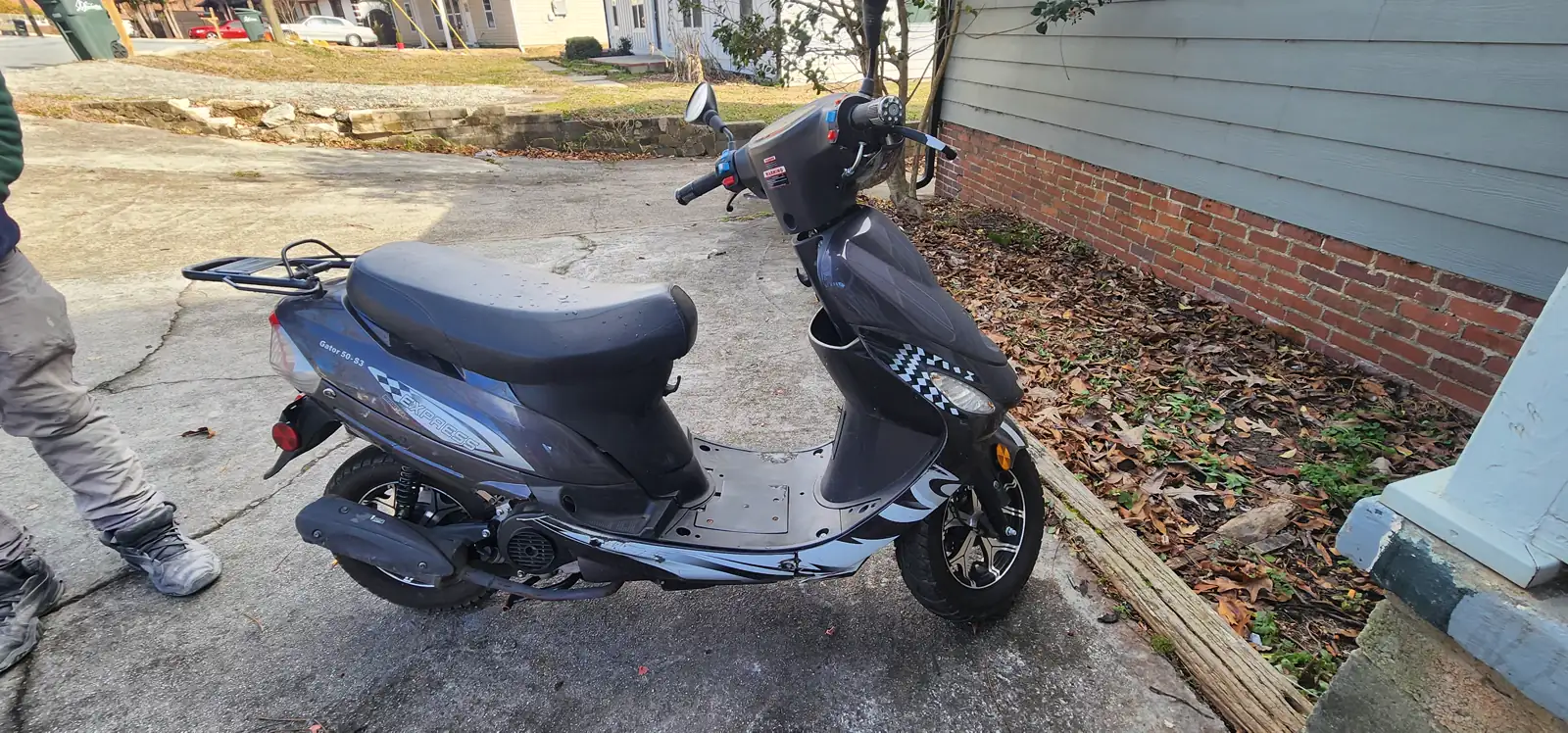indie motorcycle shop Roswell GA — black and blue 50cc scooter with side panels off exposing the engine