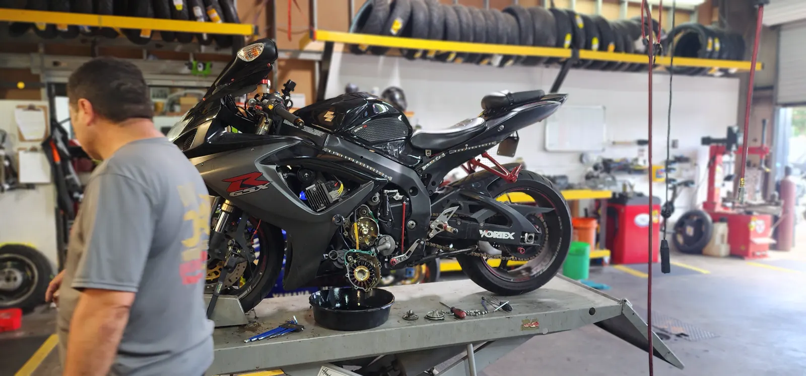 motorcycle maintenance Marietta — black Suzuki GSX-R on a lift with the engine cover off, exposing the stator and clutch