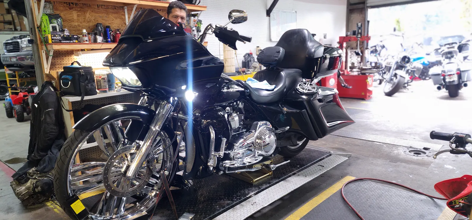 Motorcycle service Marietta — blacked-out Harley Road Glide bagger on the lift with a tech working behind the fairing