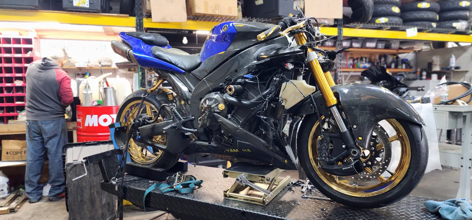 Motorcycle service Marietta — blue Yamaha R6 with carbon bodywork and gold wheels on a lift, fairings off.