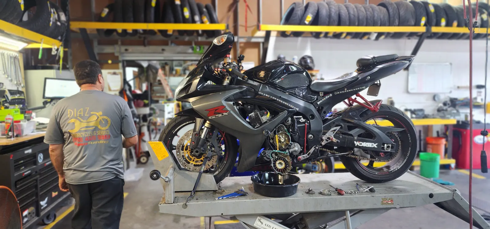 Motorcycle service Alpharetta — Diaz technician beside a black Suzuki GSX-R with fairings off on the lift
