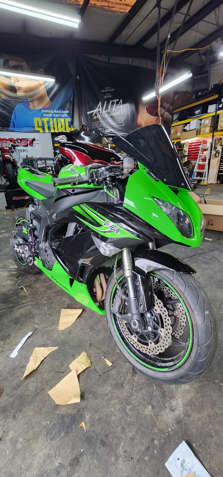 Bike maintenance Mableton — green Kawasaki Ninja ZX-6R with fairing pieces and paper templates on the shop floor