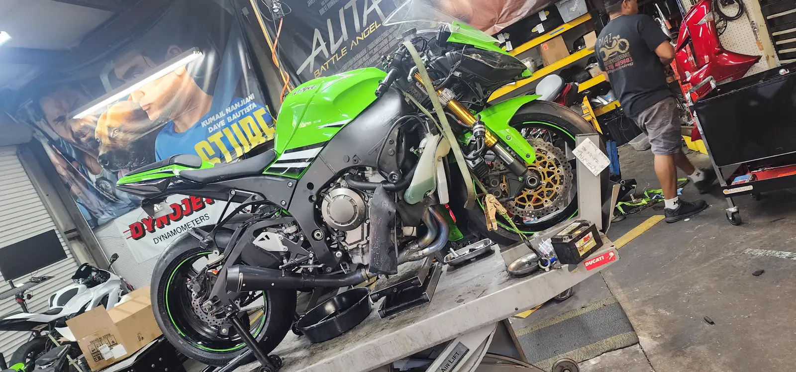 Motorcycle service East Cobb — green Kawasaki ZX-10R on a shop table with fairings off and front wheel removed