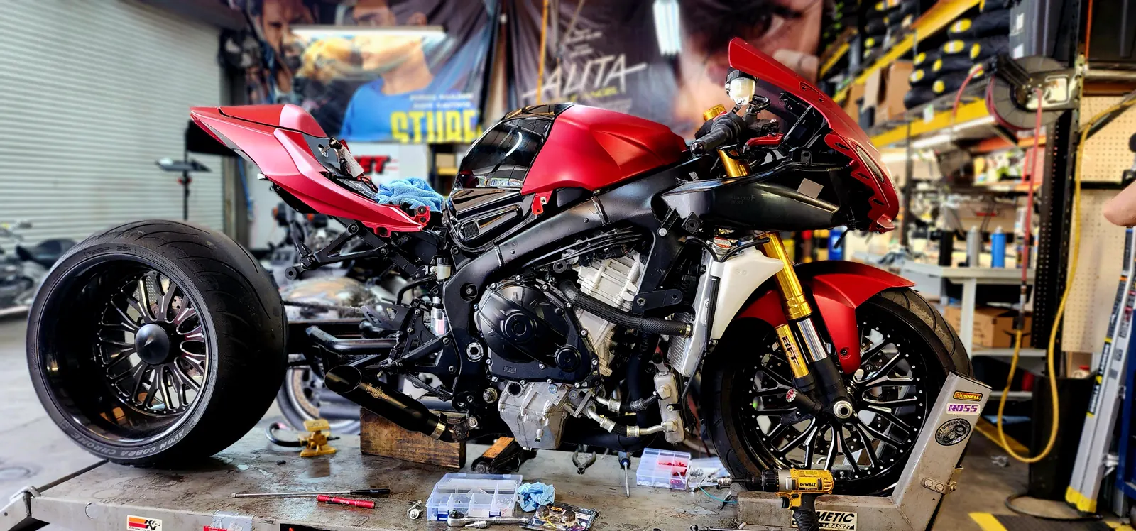 Service cost East Cobb — matte red Suzuki Hayabusa stripped of fairings on a lift with parts trays laid out