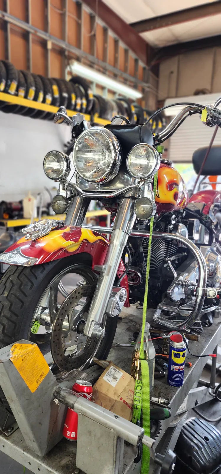 Motorcycle service Lawrenceville — red Harley-Davidson cruiser with flame paint strapped on a shop lift
