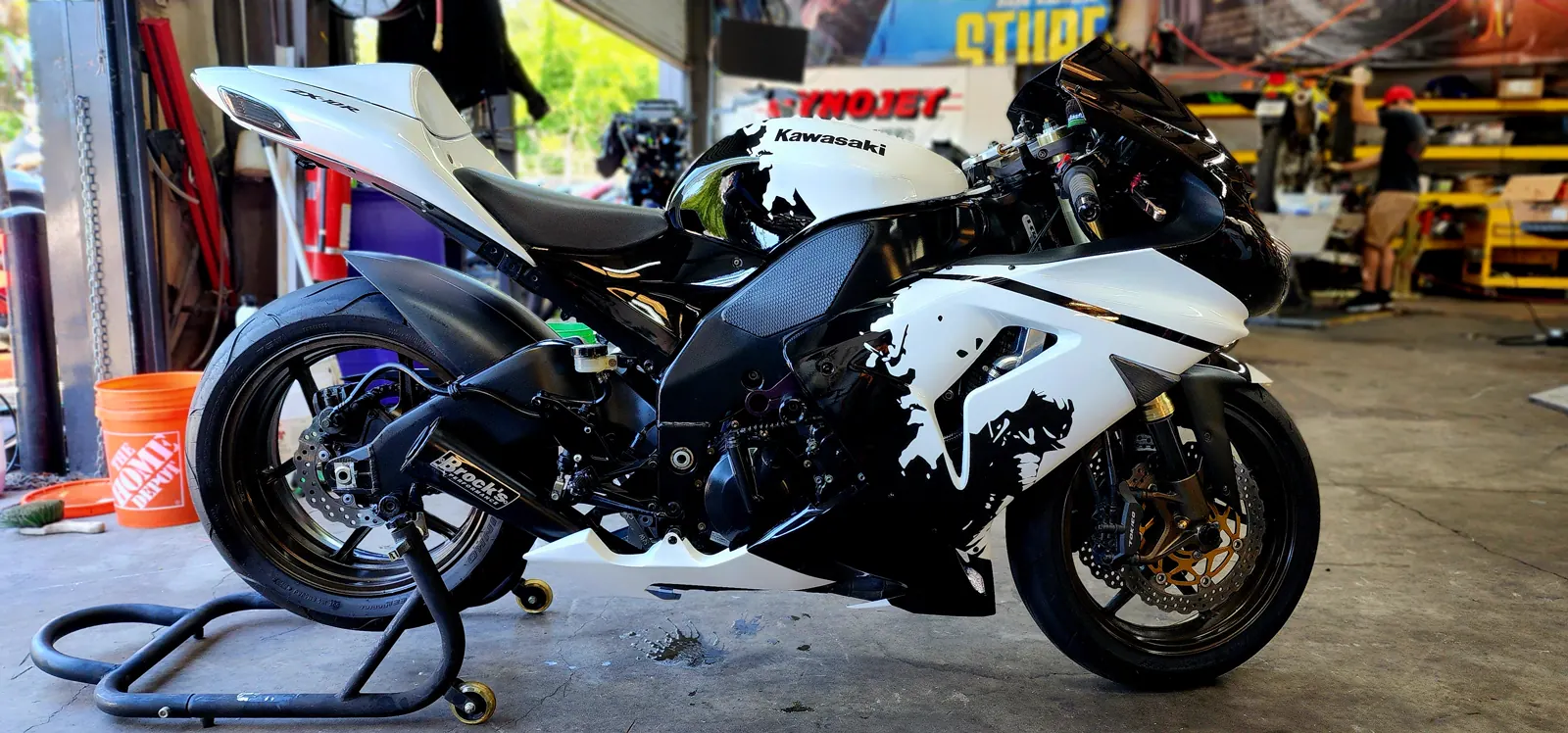 Catching overdue motorcycle service Acworth riders skip — white and black Kawasaki ZX-10R on a paddock stand in the shop