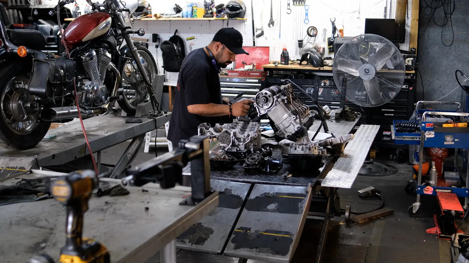 Motorcycle service Acworth riders drive for — tech at the bench with a torn-down engine and a Honda Shadow on the lift