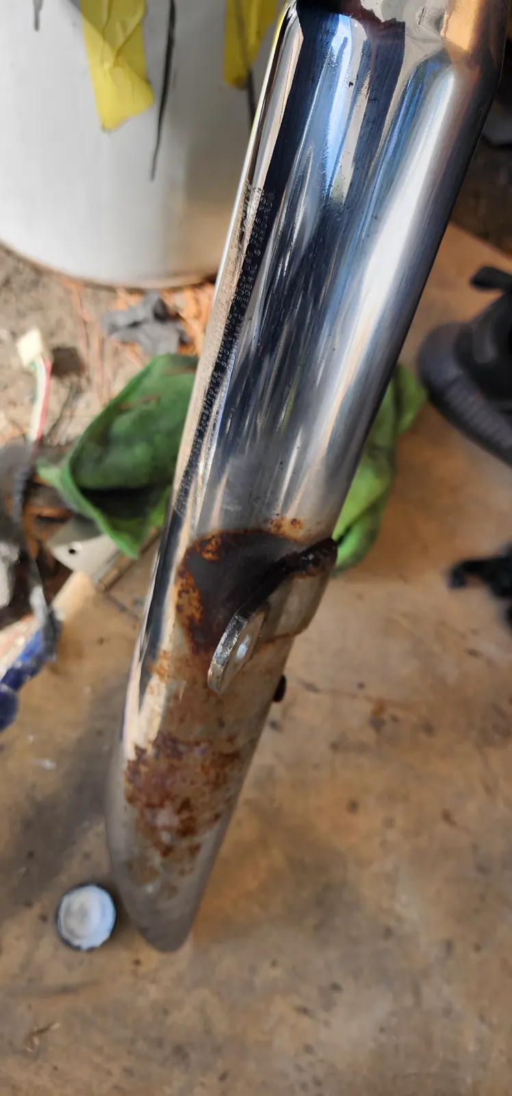 motorcycle restoration Smyrna — close-up of a chrome exhaust pipe showing heavy rust and pitting on the lower half