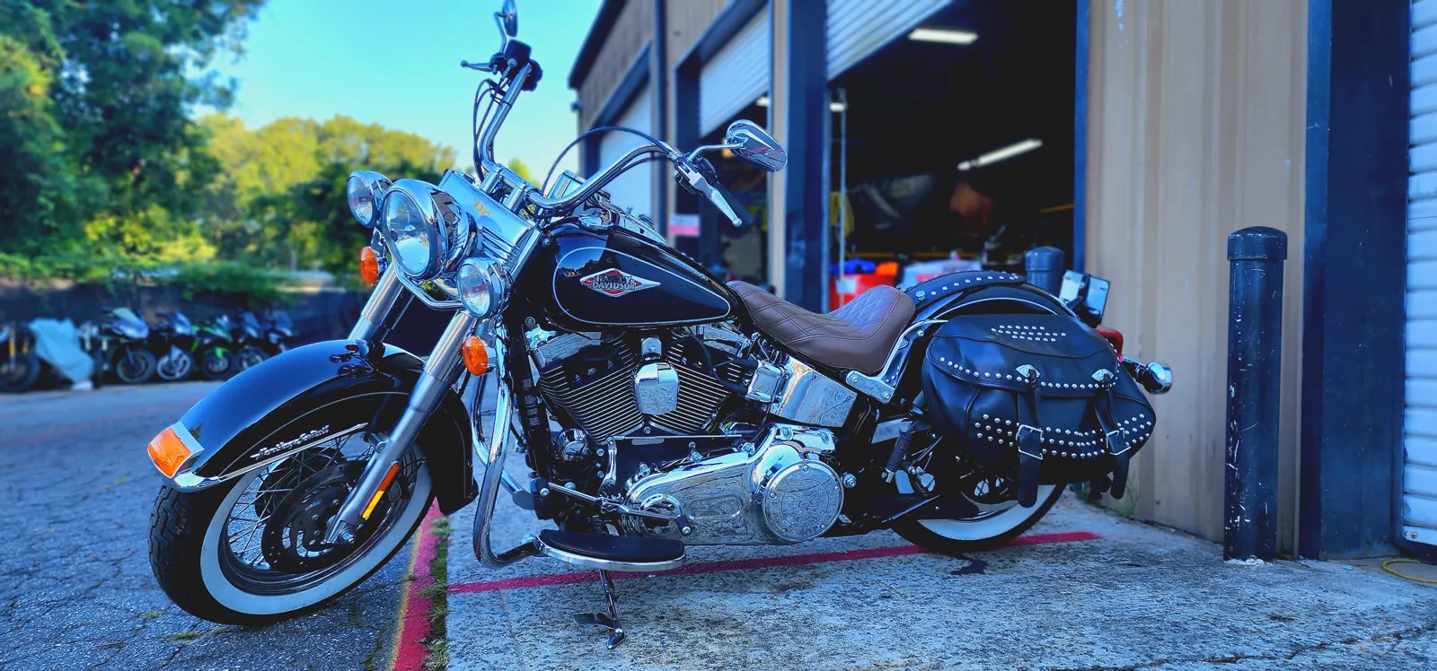 Motorcycle service Marietta — black Harley Heritage Softail with whitewalls and studded saddlebags by a bay door.
