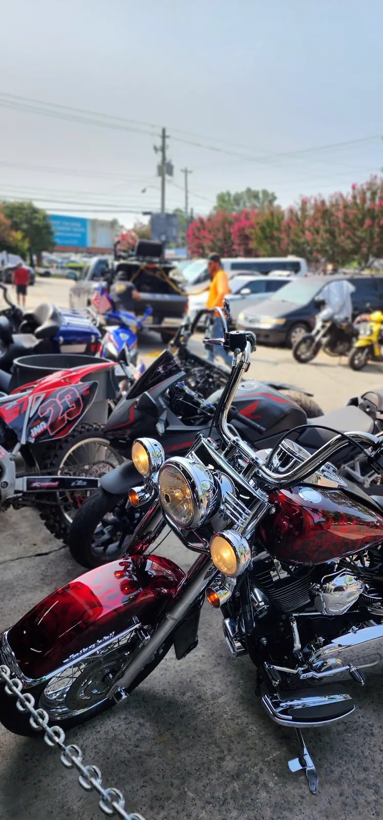 Motorcycle pickup Roswell — candy red flamed Harley Softail in the busy Diaz shop lot with dirt bikes and a Honda naked bike
