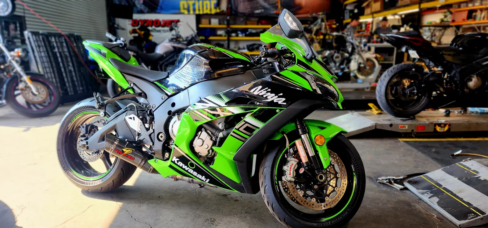 East Cobb repair shop floor — clean green and black Kawasaki Ninja ZX-10R with a Dynojet banner behind it