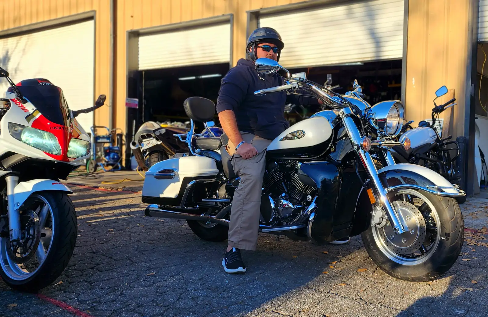 motorcycle pickup East Cobb — man seated on a white Yamaha Road Star with polished chrome forks, red Honda CBR at left