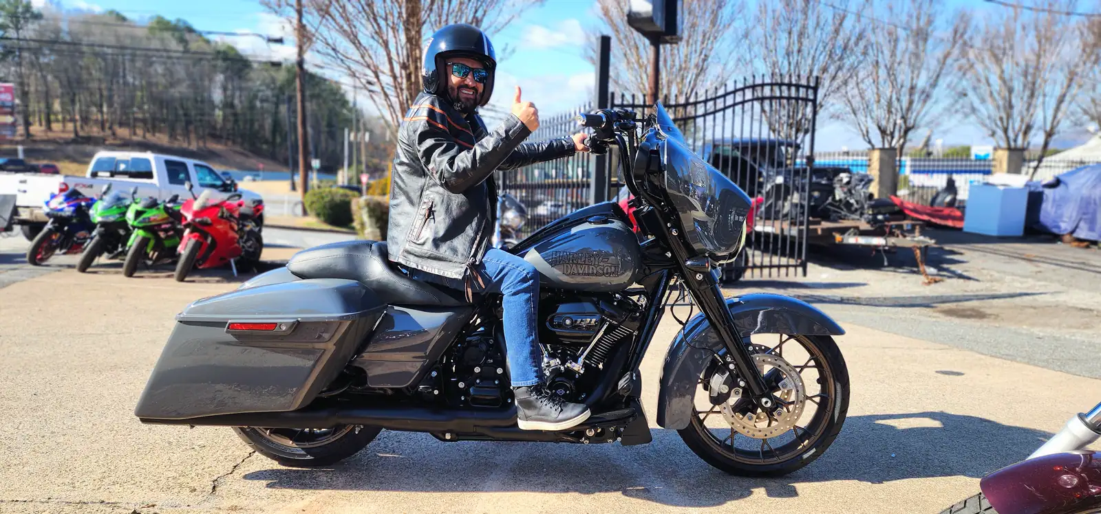 motorcycle transport East Cobb — customer in helmet and leather jacket on a grey Harley Street Glide, thumbs up