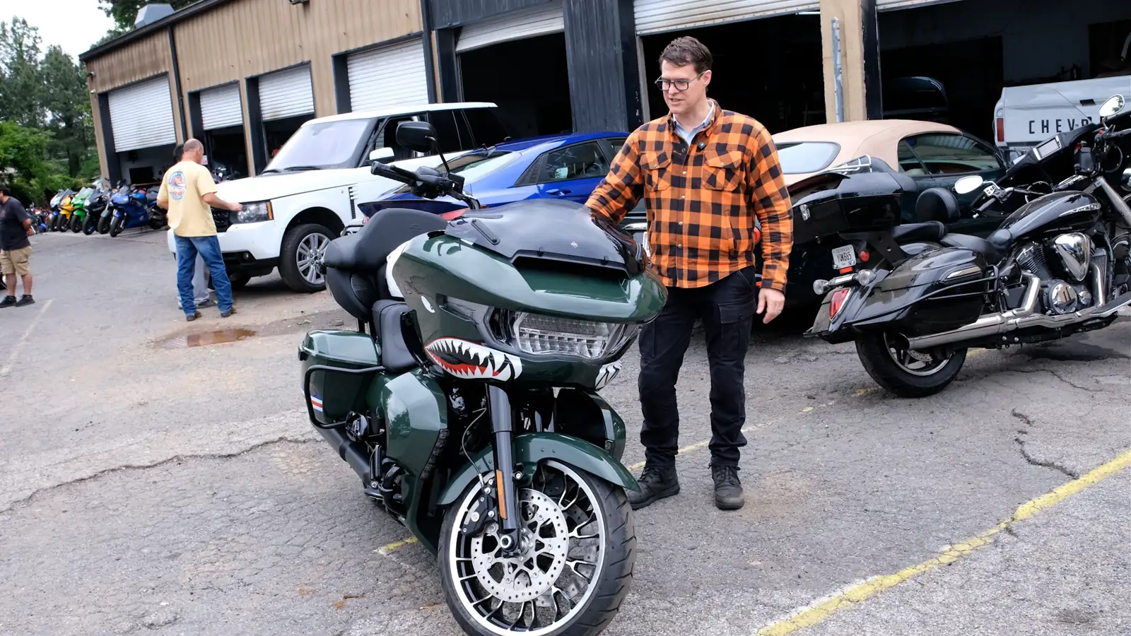 Motorcycle transport Roswell — customer in orange plaid walking up to a green shark-mouth Indian bagger in the Diaz shop lot