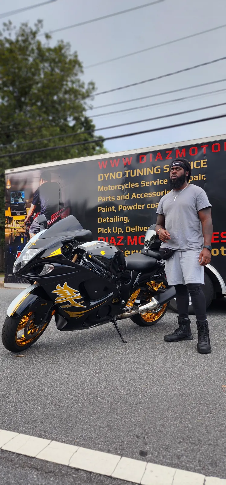 enclosed transport East Cobb — customer beside a black-and-gold Hayabusa in front of the Diaz enclosed trailer