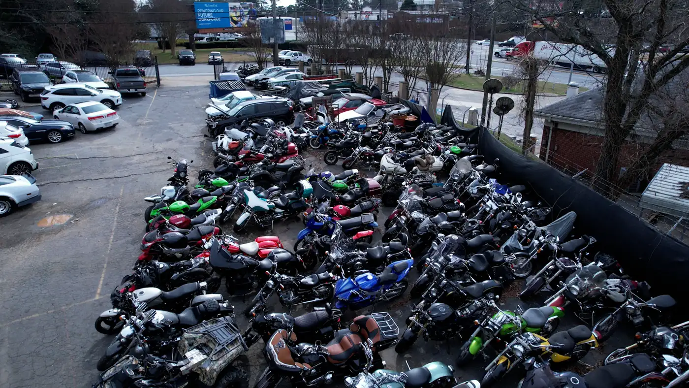 Motorcycle shop serving Smyrna — wide elevated view of the rear lot with bikes, scooters and ATVs parked in rows