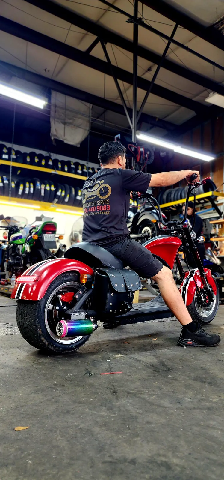 Motorcycle shop serving Mableton — man in a Diaz Motorcycles shirt on a red fat-tire electric chopper scooter