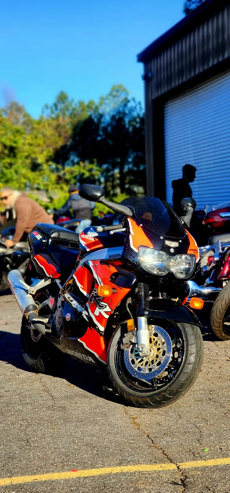 Motorcycle maintenance Lawrenceville riders trust — orange and black Honda CBR sportbike parked outside the shop
