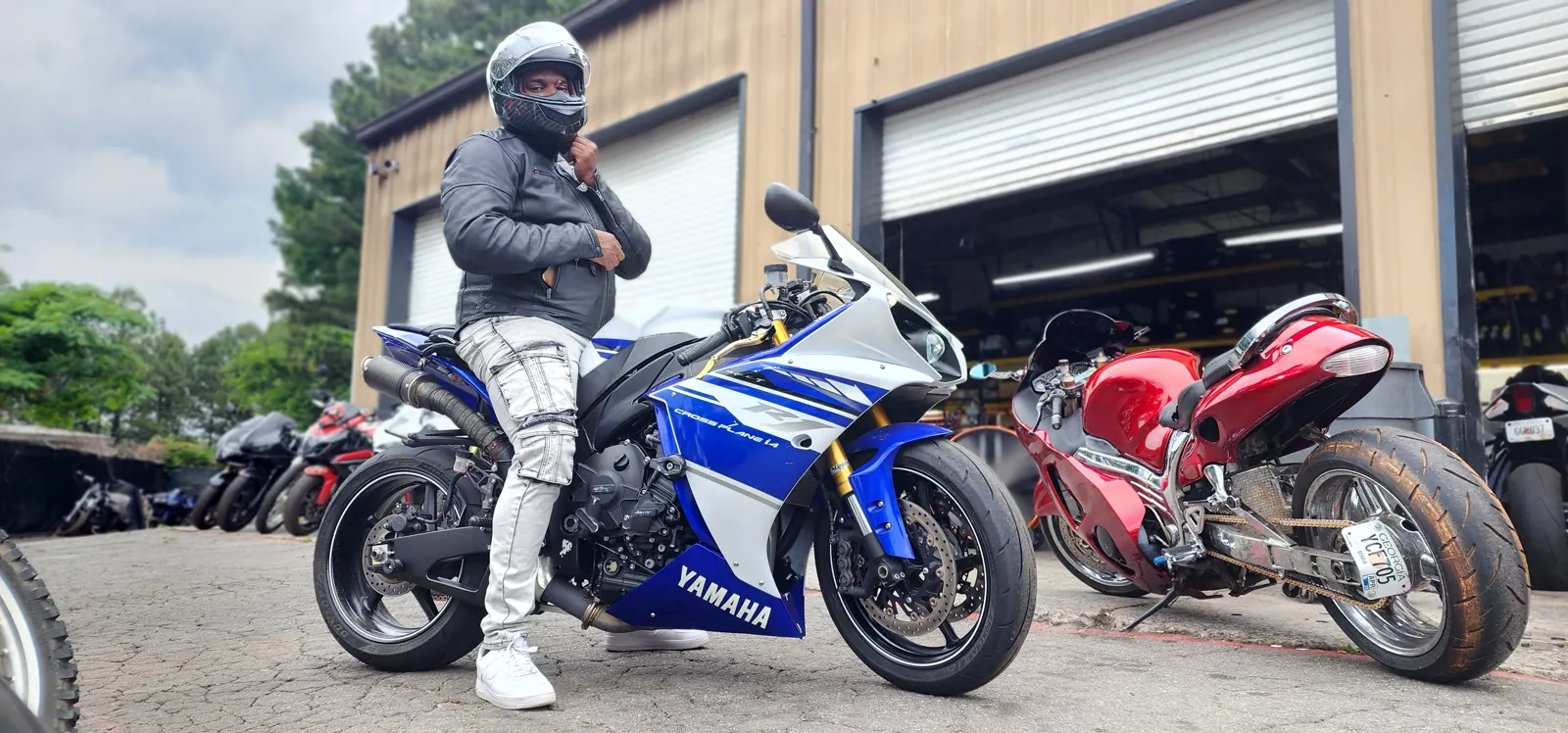 Motorcycle service Roswell — rider in a leather jacket and silver helmet leaning on a blue and white Yamaha R1 outside