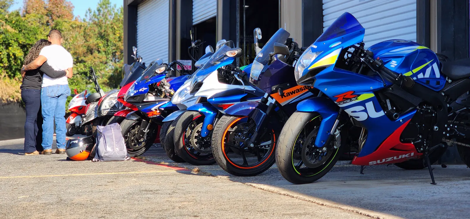 Motorcycle service Roswell riders use — row of sportbikes nose-in at the bay doors led by a blue Suzuki GSX-R