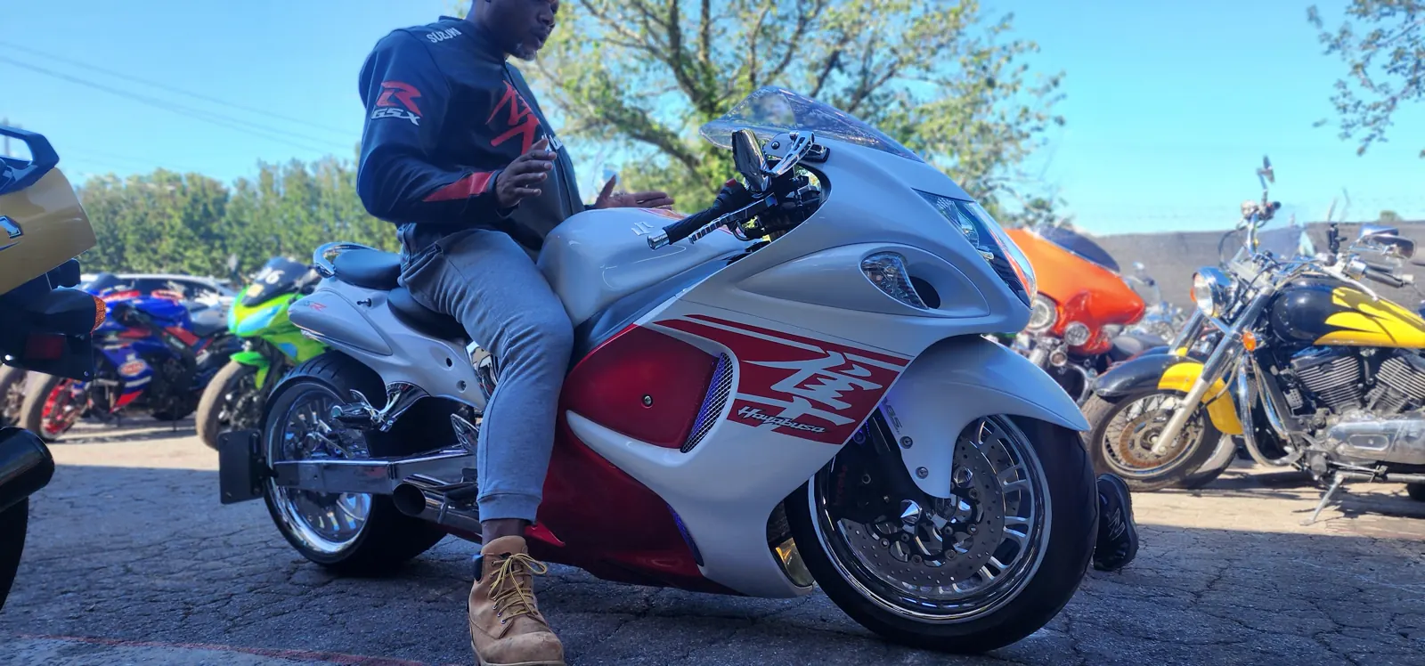 Enclosed vs open transport Mableton — white and red Suzuki Hayabusa with a rider seated in the shop lot.