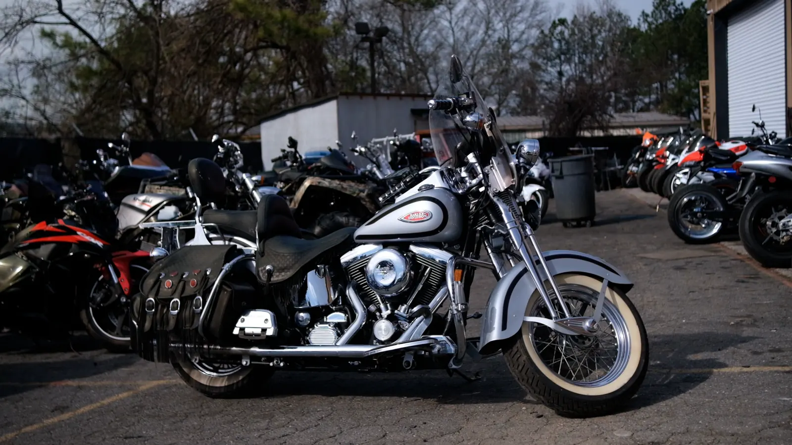 Motorcycle transport Mableton — silver and black Harley Softail with whitewalls in the Diaz lot at low sun