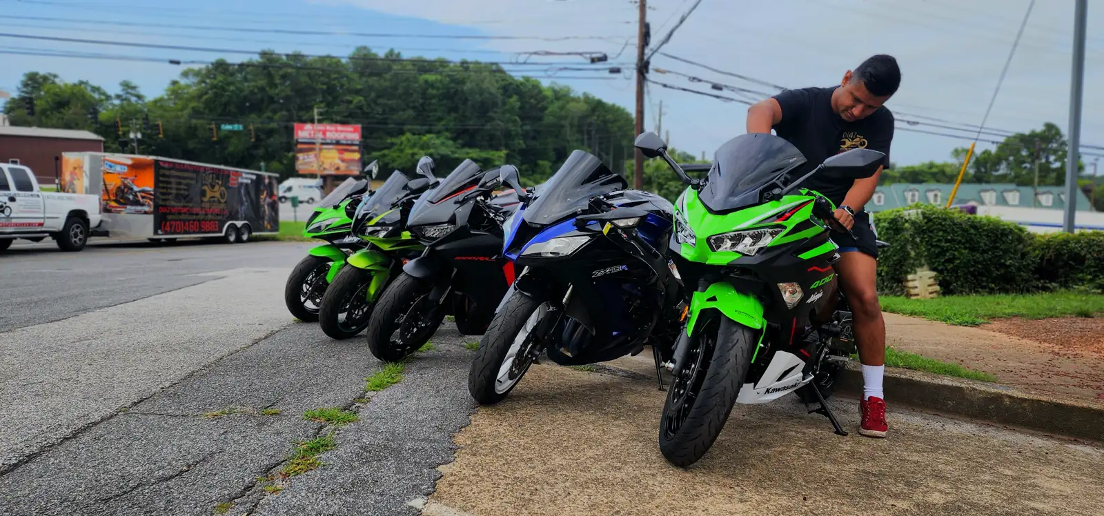 Stranded motorcycle pickup Woodstock — Diaz staff member positions a green Kawasaki Ninja in a curbside row