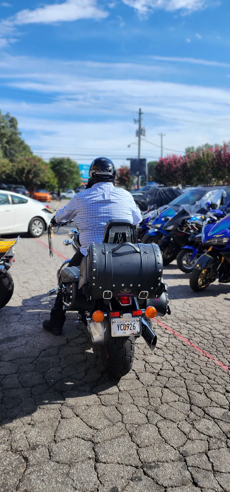 best motorcycle transport Woodstock — rider on a black cruiser with leather saddlebags, blue Yamaha sportbikes lined up behind