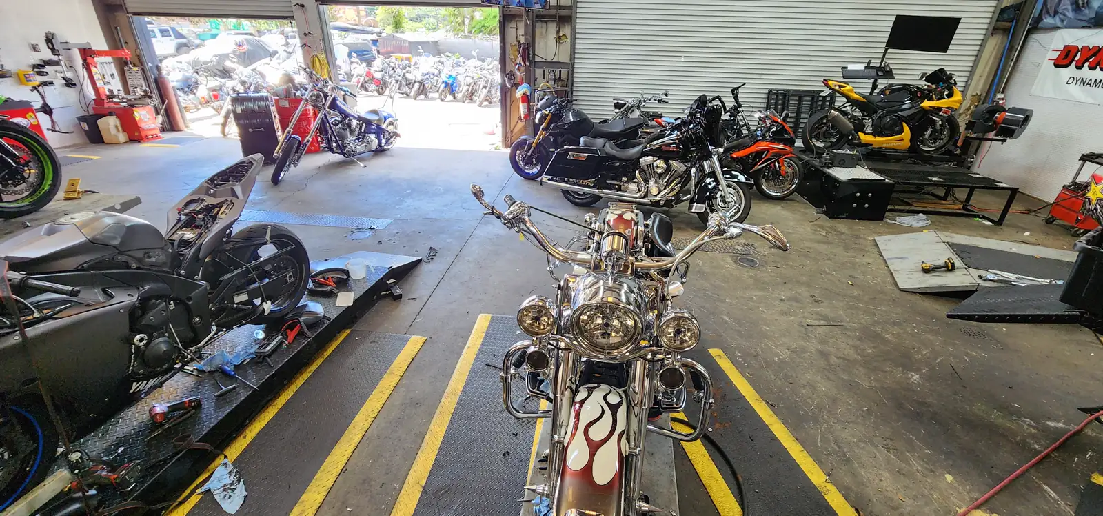 motorcycle transport Canton — view down the Diaz shop floor with a flame-painted Harley on the lift
