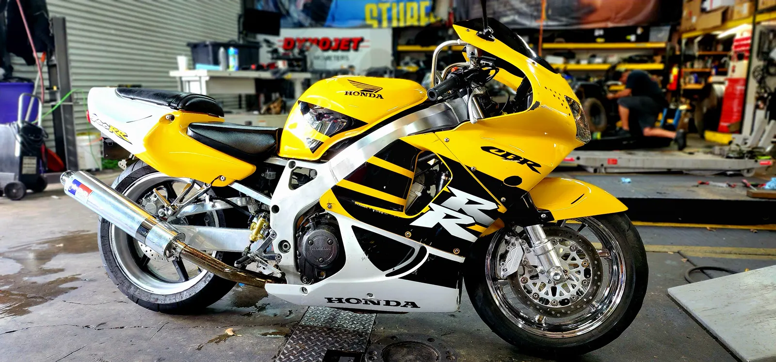 Canton motorcycle service — yellow and white Honda CBR on the Diaz shop floor by the Dynojet banner