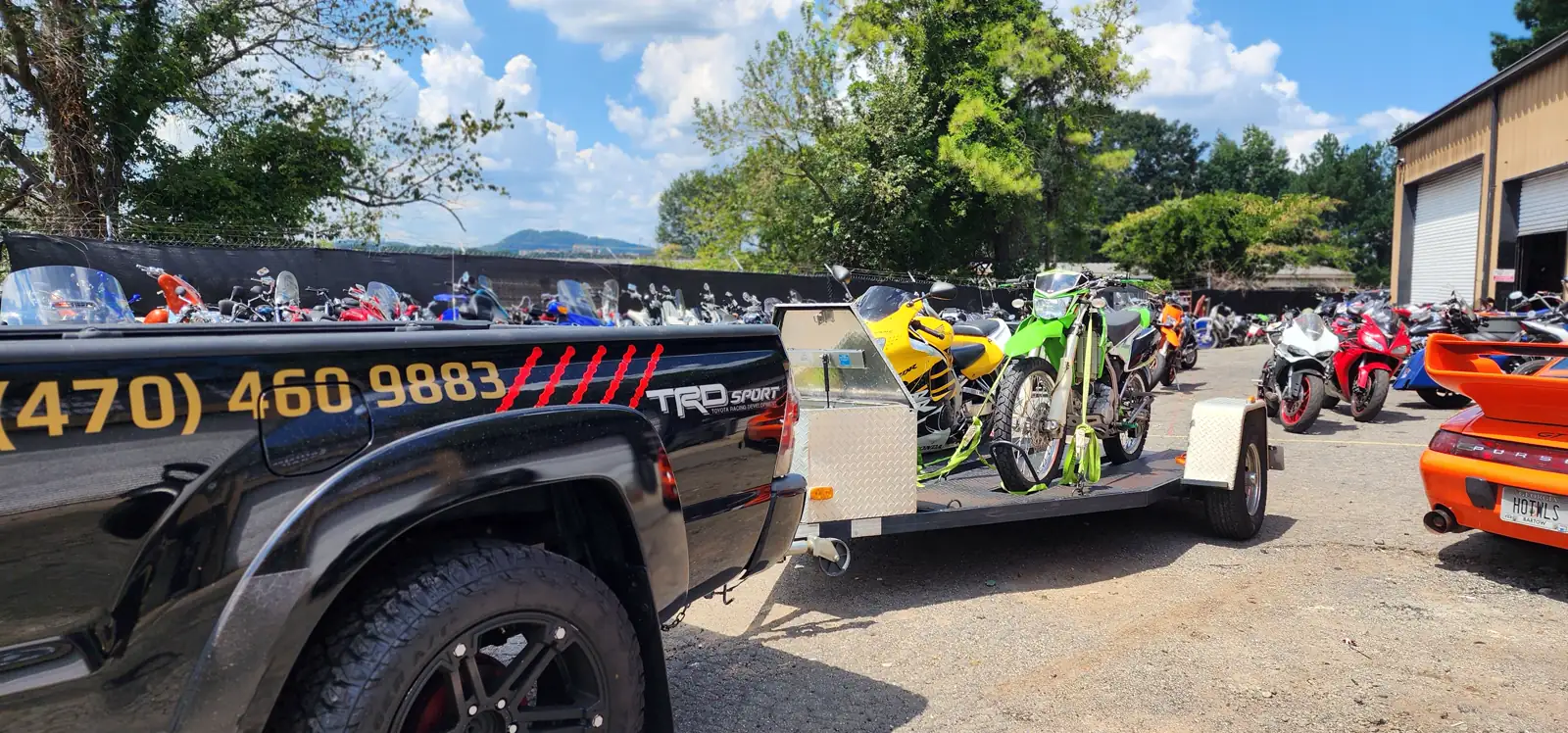Stranded motorcycle pickup Mableton — Diaz pickup towing a trailer loaded with a yellow and green dirt bike