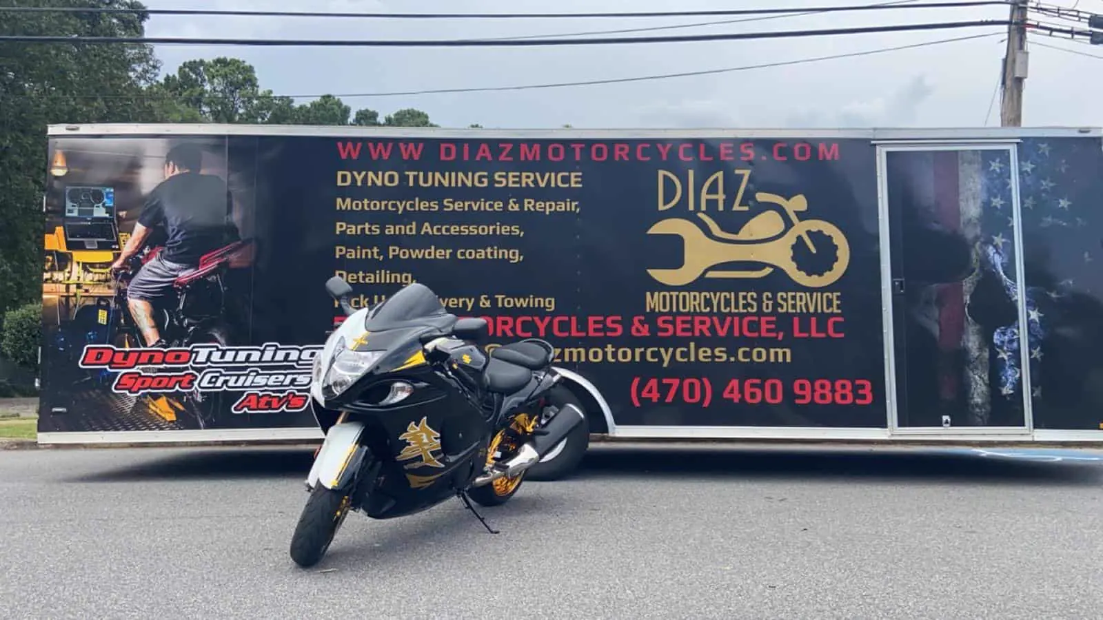 Motorcycle transport cost Marietta — black and gold Suzuki Hayabusa in front of the branded Diaz enclosed trailer