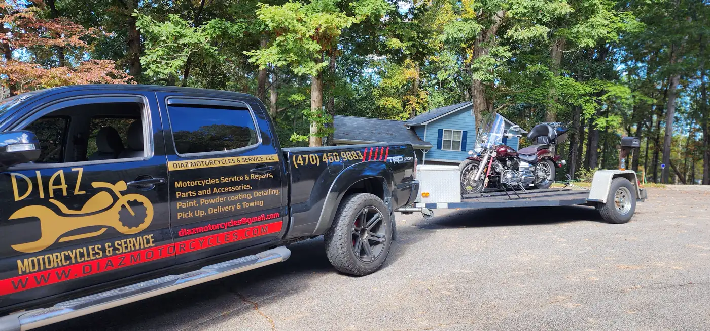 Motorcycle transport Mableton — Diaz Toyota Tacoma towing an open flatbed with a maroon Harley cruiser