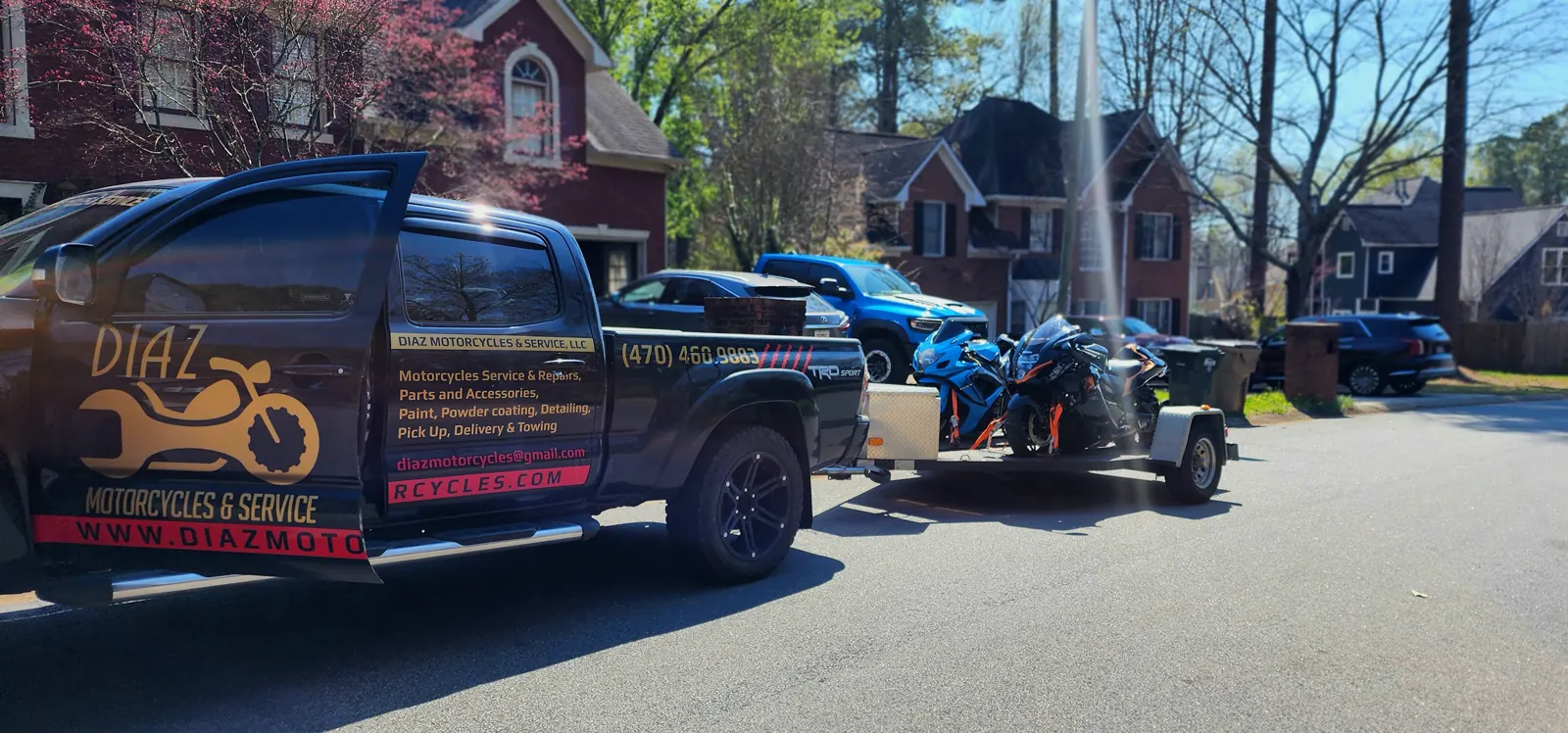 Best motorcycle transport Marietta — blue Suzuki GSX-R and black KTM strapped side by side on an open Diaz trailer