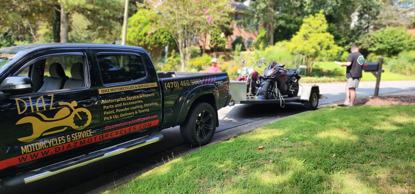 Best motorcycle transport Acworth — Diaz Tacoma and open trailer with two bikes parked by a residential mailbox