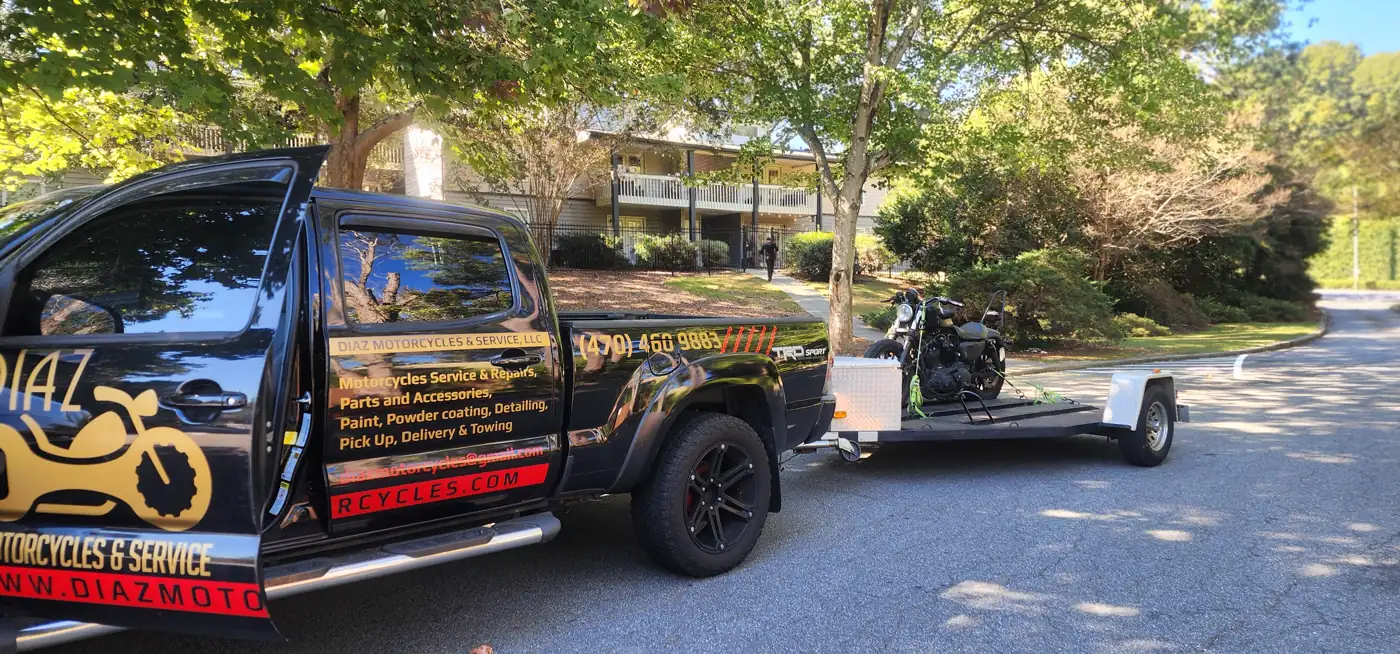 motorcycle transport Canton — Diaz Tacoma towing a black cruiser on a tree-lined residential street