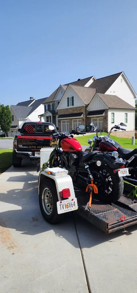 Rear view of the Diaz Tacoma and open trailer loaded with a red Harley Forty-Eight and other cruisers, parked in a suburban driveway.