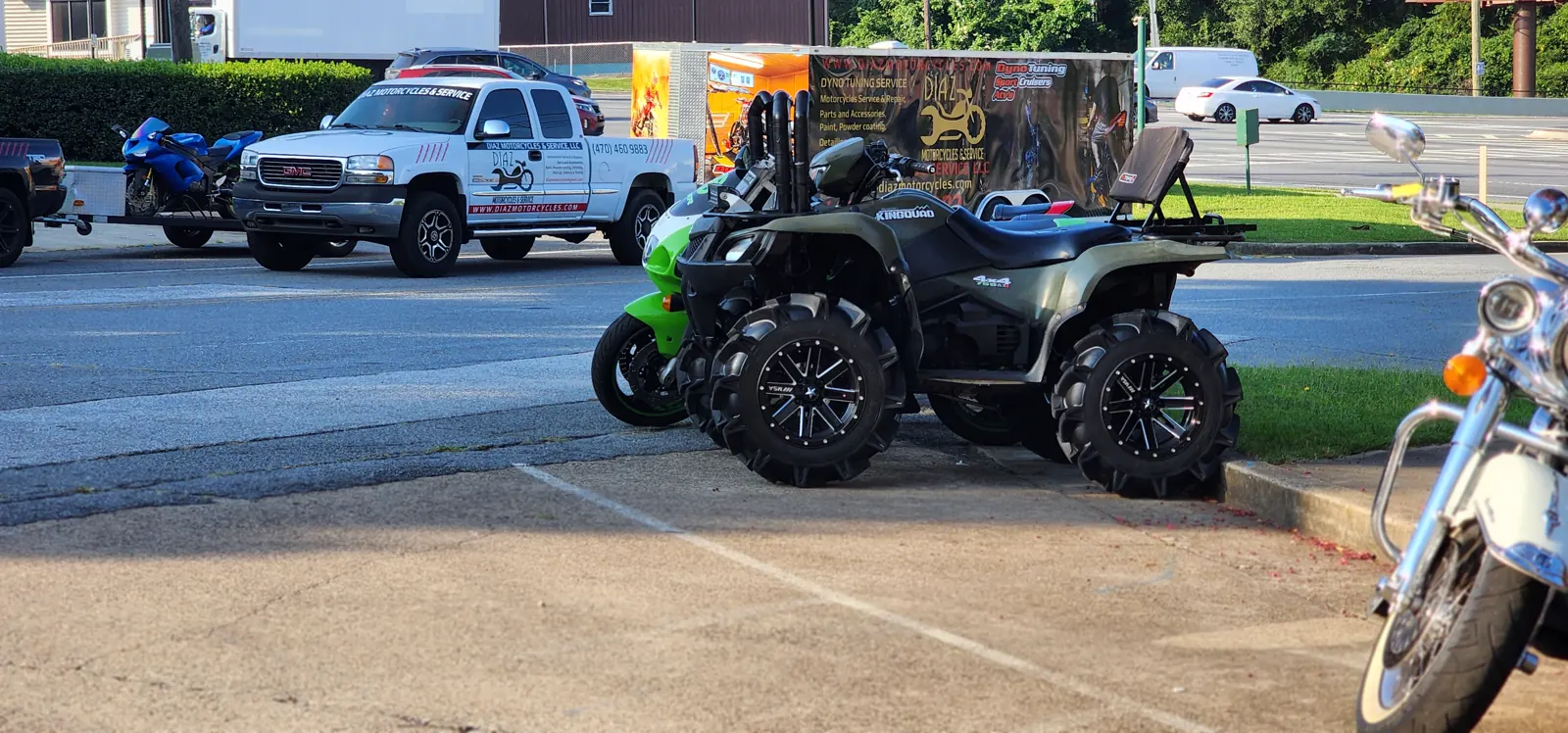 shipping cost Powder Springs — white GMC pickup with Diaz decals towing a blue sportbike beside the enclosed trailer