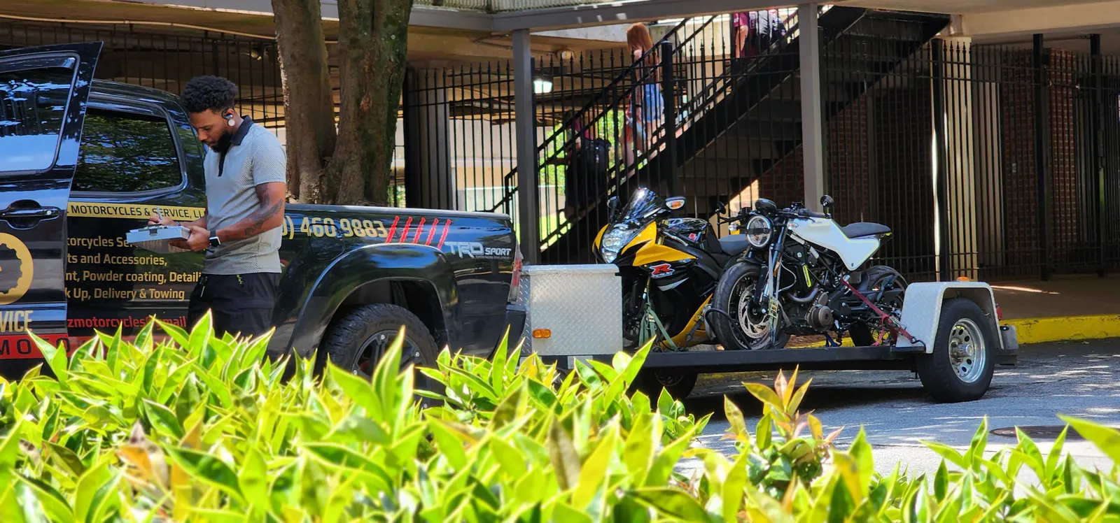 enclosed transport Powder Springs — clipboard pickup scene with truck, loaded trailer, and a yellow-black sportbike